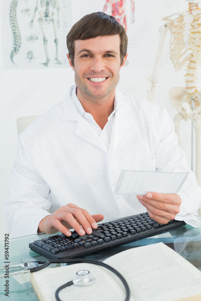 Portrait of a male doctor reading a note at desk Portrait of a male doctor reading a note at desk