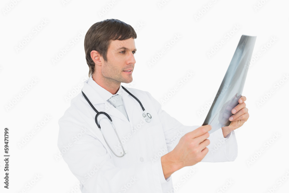 Concentrated male doctor looking at x-ray picture of lungs Concentrated male doctor looking at x-ray picture of lungs