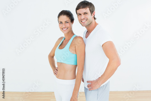 Portrait of a fit couple in fitness studio