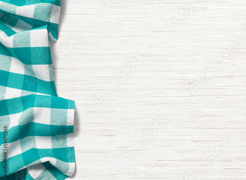 folded cyan tablecloth on bleached wooden table