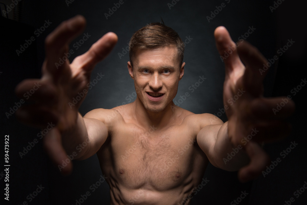 Close up of fit shirtless man stretching his arms to the camera Close up of fit shirtless man stretching his arms to the camera
