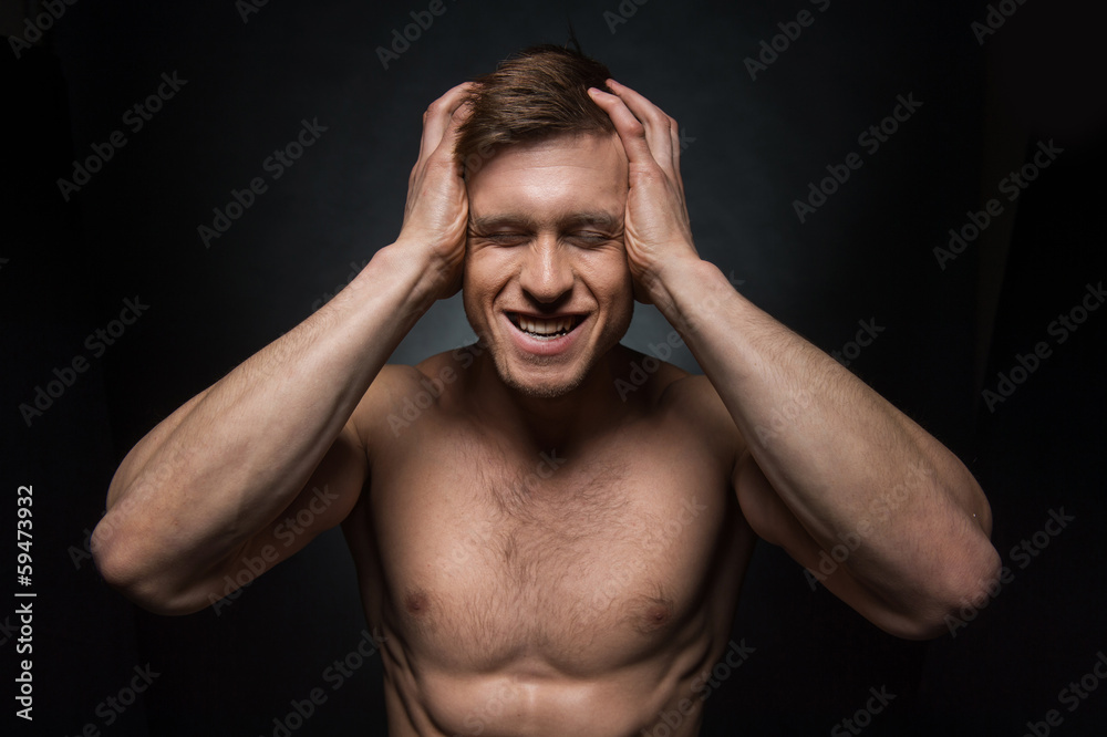 Portrait of sexy shirtless fit man holding his head Portrait of sexy shirtless fit man holding his head
