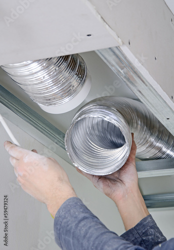 Male hands setting up ventilation system indoors