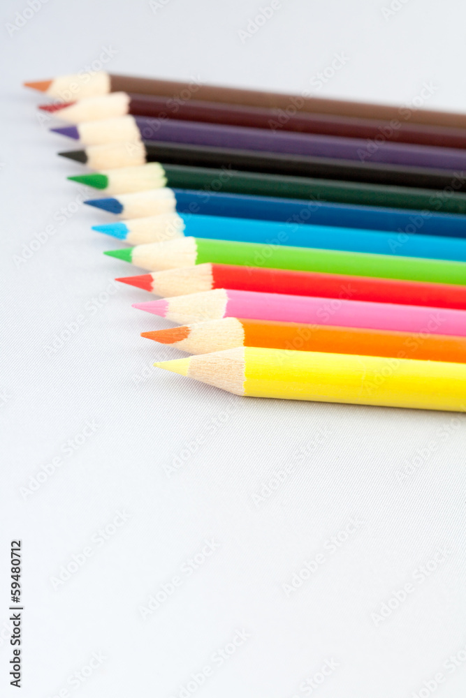 Fototapeta premium Twelve colored pencils on gray background.