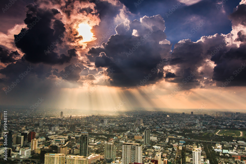 Rays of light shining through dark clouds over Bangkok, Thailand