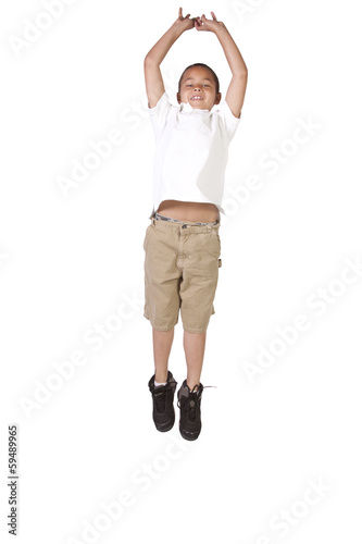 Young boy jumping over white background
