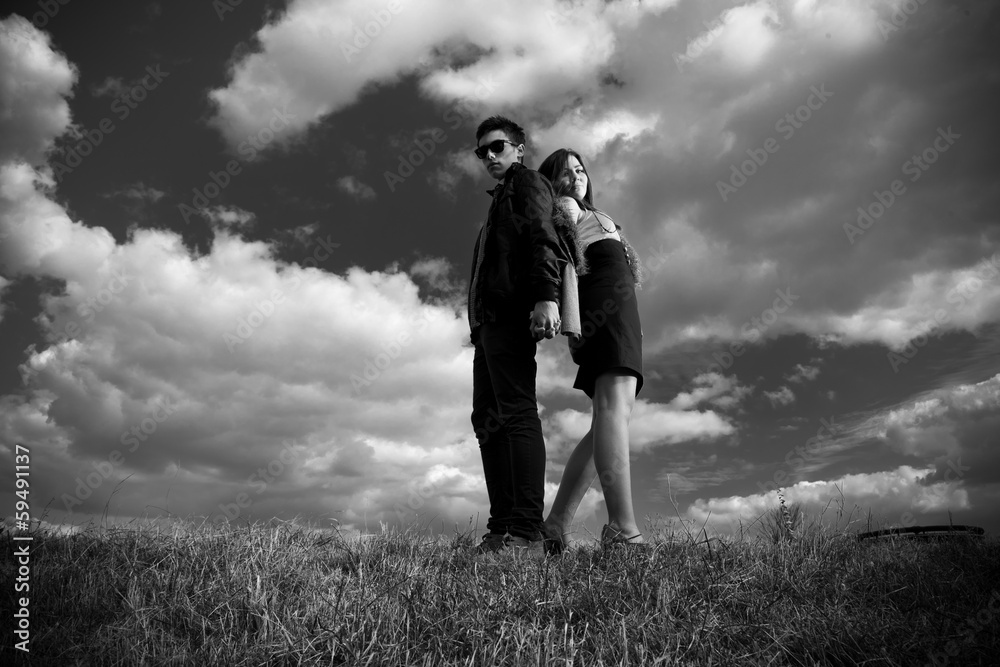 photo of sexy couple posing on top of hill back to back