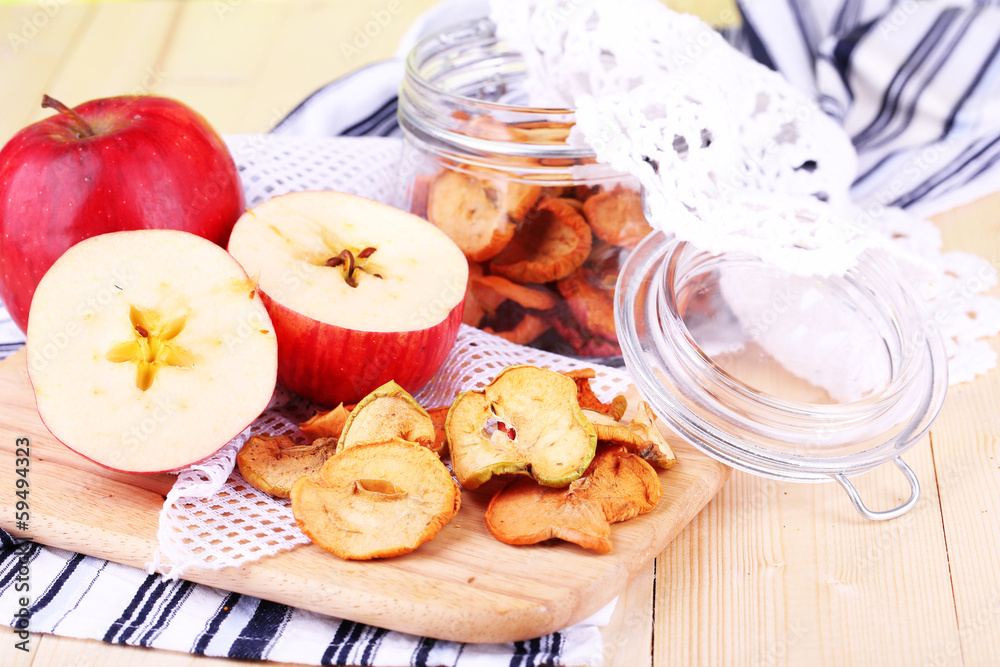 Dried apples in glass jar, on color wooden background Dried apples in glass jar, on color wooden background