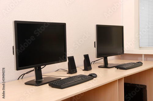 Computers on tables in room