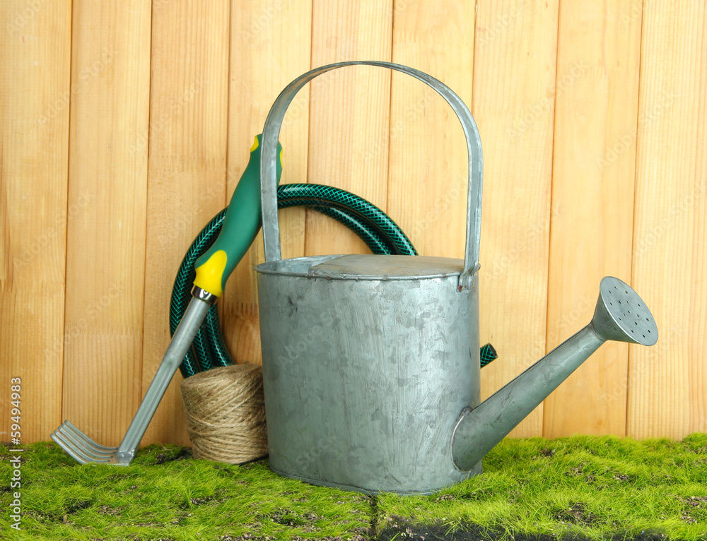 Gardening tools on grass on wooden background Gardening tools on grass on wooden background