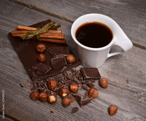 Pieces of dark chocolate, cinnamon and cup of coffee