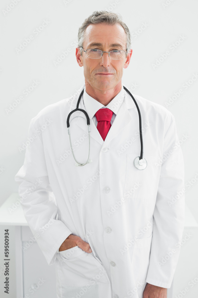 Confident male doctor standing in medical office Confident male doctor standing in medical office