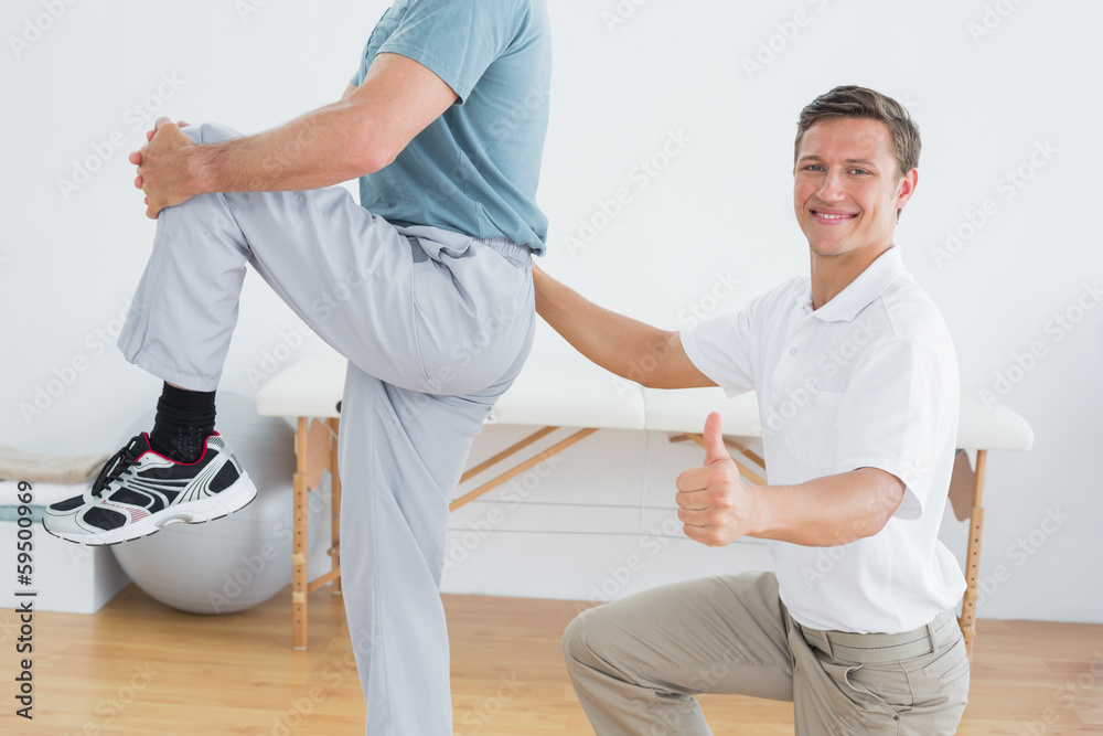 Obraz premium Therapist massaging mans lower back while gesturing thumbs up