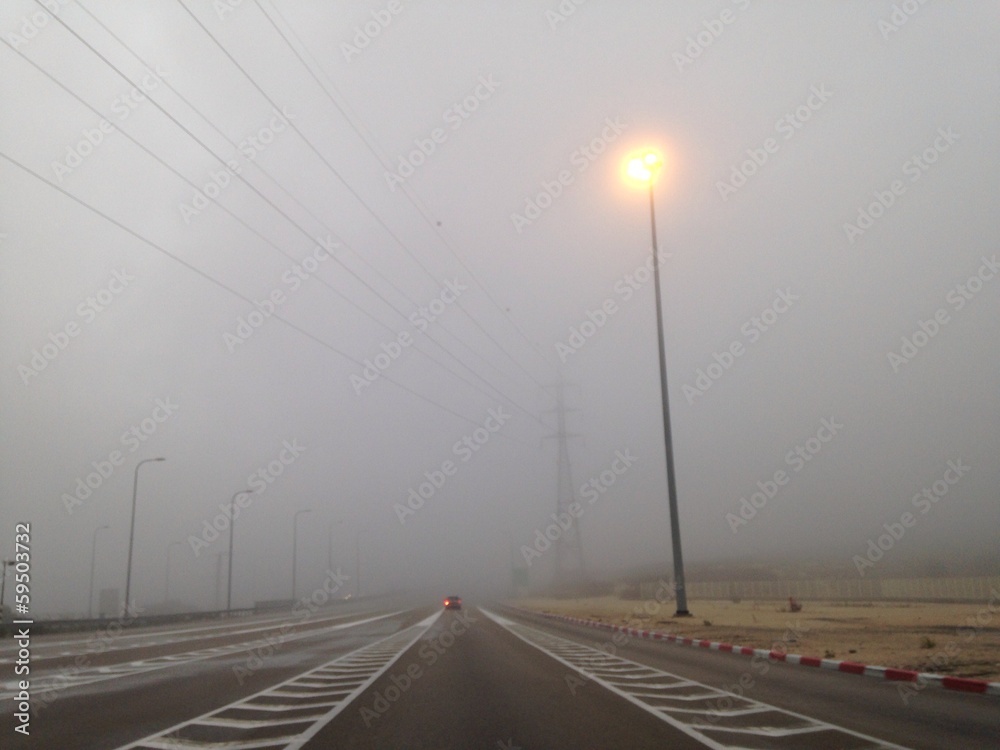 single car on an empty road in fog