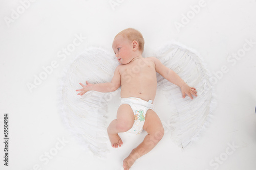 Cute little baby flying with angel wings. photo