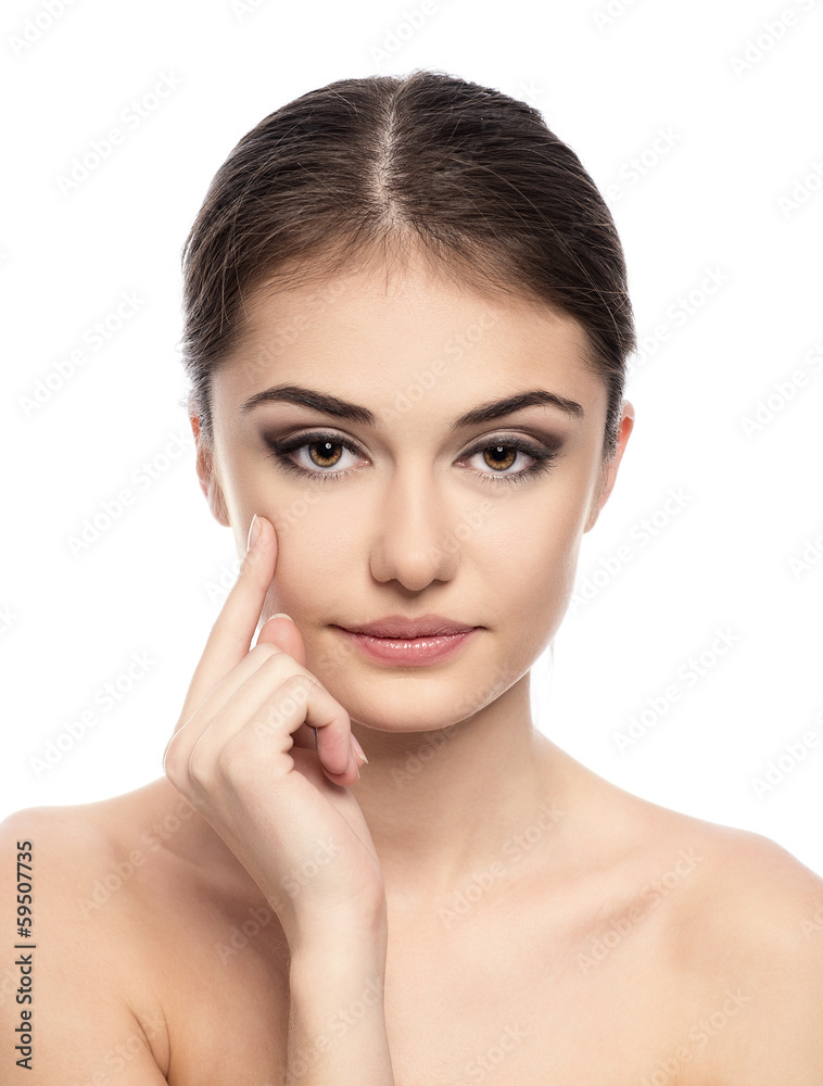 Lovely female brunette applying cream on her face