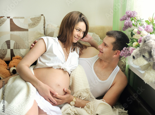 Couple future parents relaxing at home.