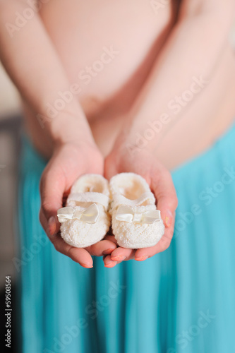 Pregnant belly with newborn baby booties