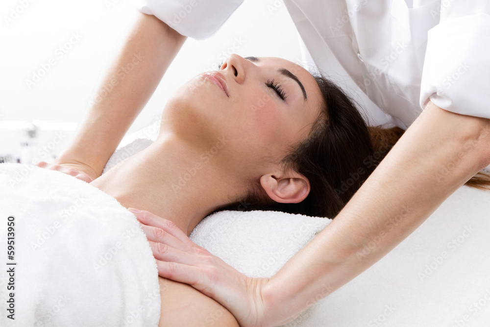 Woman enjoying shoulder massage at beauty spa