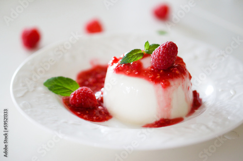 Delicious italian dessert panna cotta with raspberry sauce and m photo
