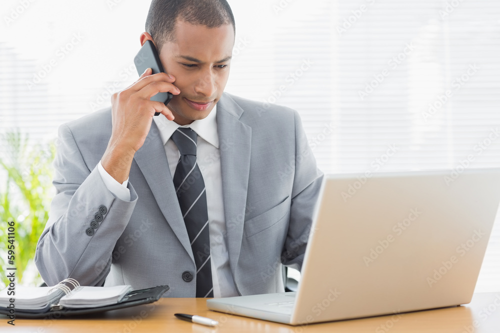 Businessman using laptop and cellphone at office Businessman using laptop and cellphone at office
