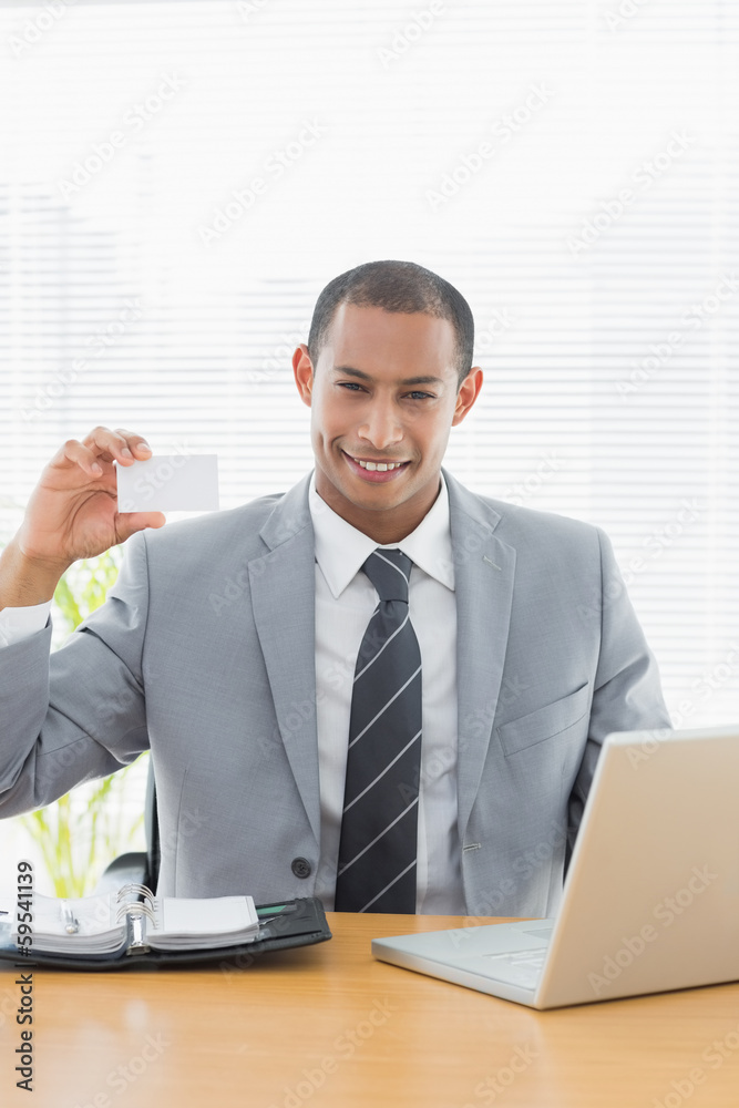 Confident well dressed man with business card at office desk Confident well dressed man with business card at office desk