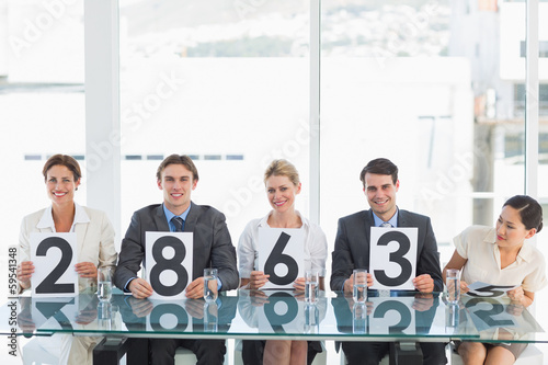 Group of panel judges holding score signs