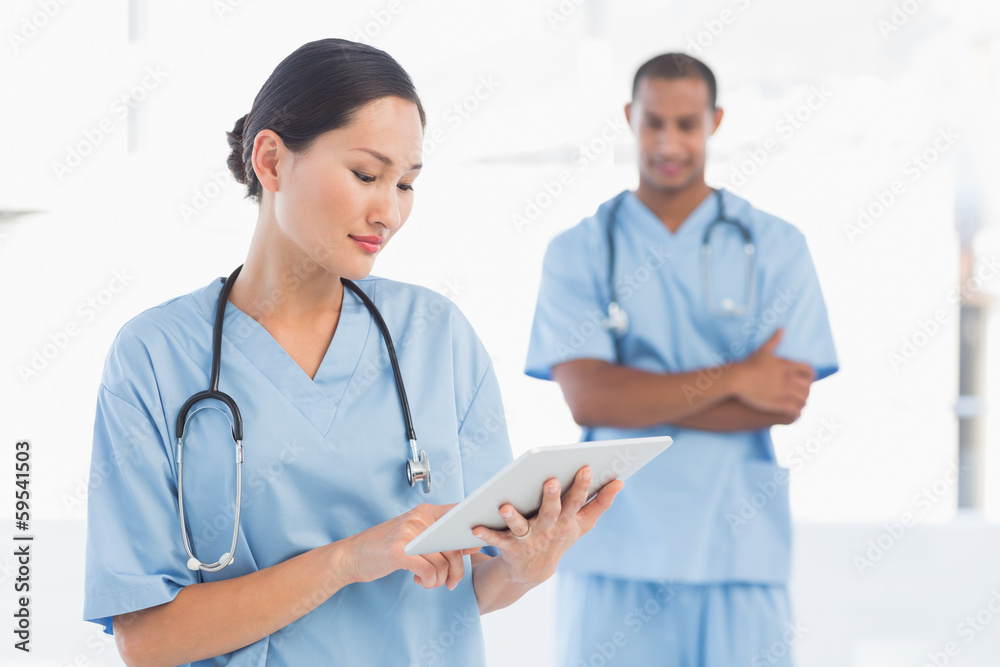 Beautiful female surgeon holding digital tablet