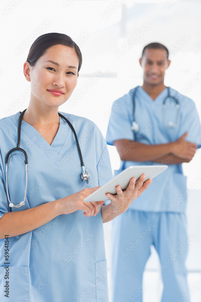 Beautiful female surgeon holding digital tablet Beautiful female surgeon holding digital tablet