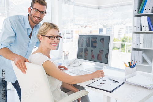 Side view portrait of photo editors working on computer