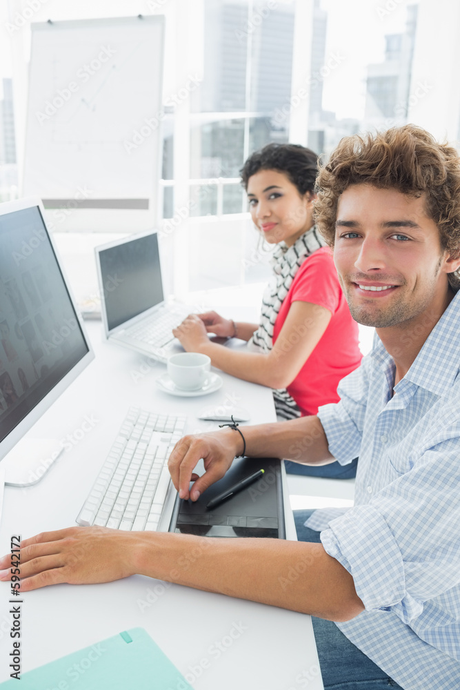 Casual couple using computers in office Casual couple using computers in office