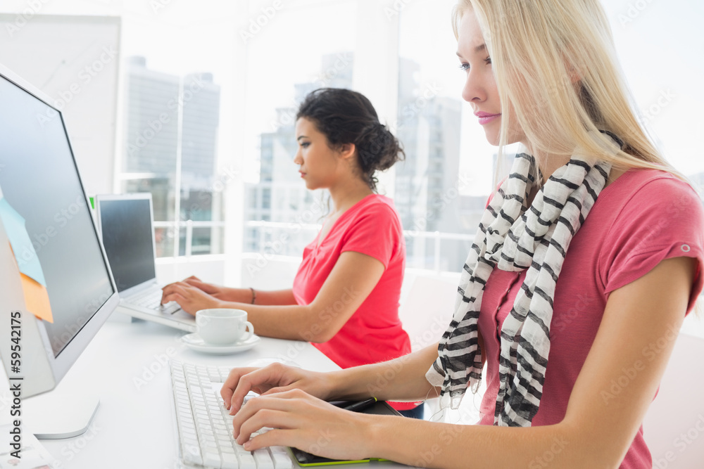Casual young women using computers in office