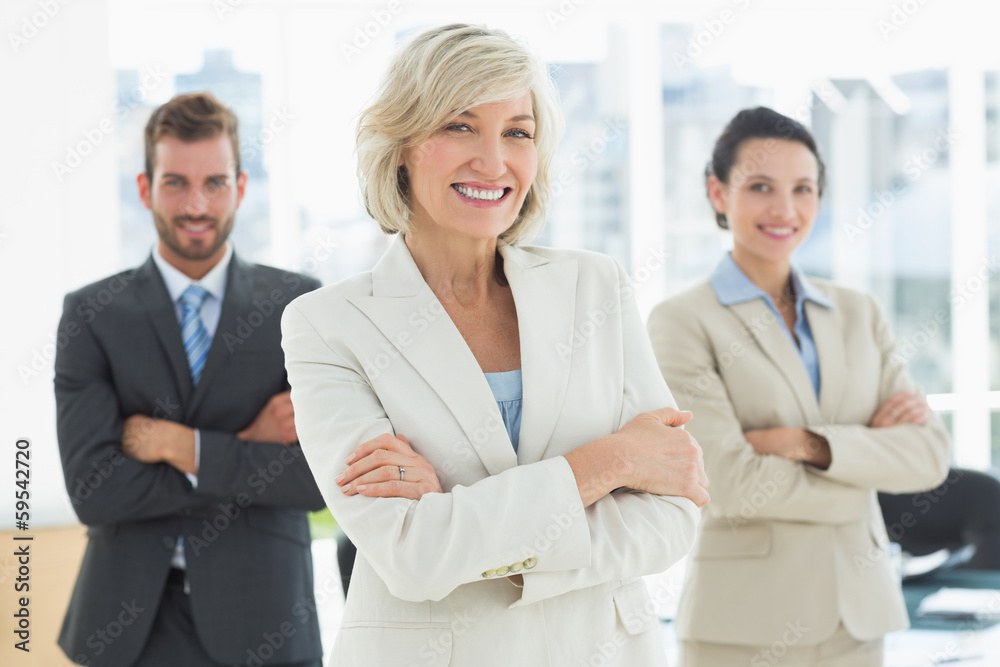 Confident business team with arms crossed in office Confident business team with arms crossed in office