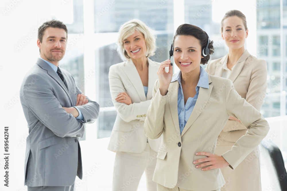 Businesswoman wearing headset with colleagues in office Businesswoman wearing headset with colleagues in office