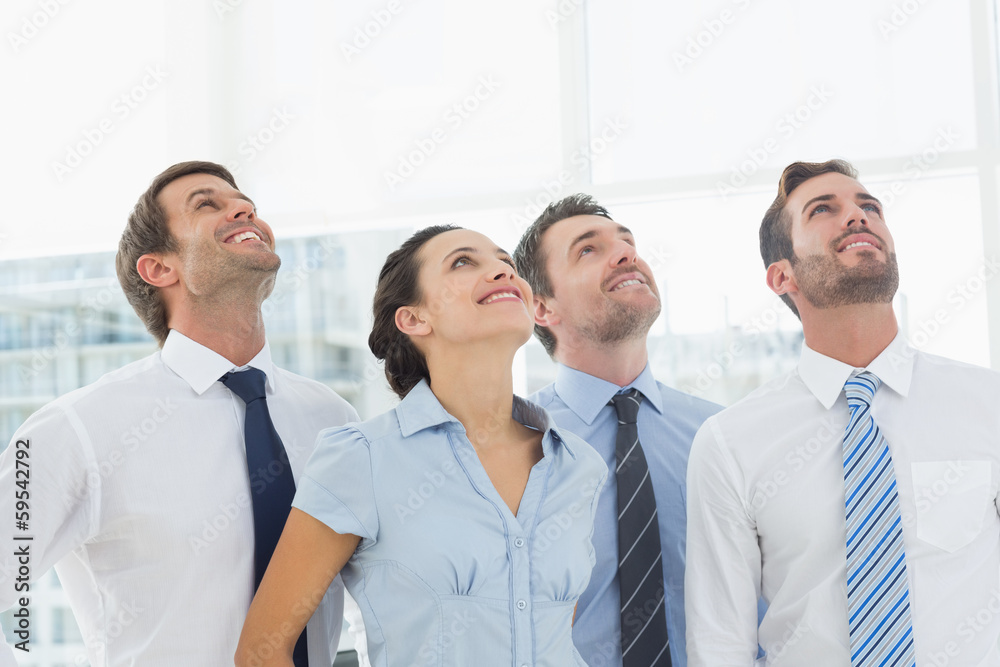 Smiling business team looking up Smiling business team looking up