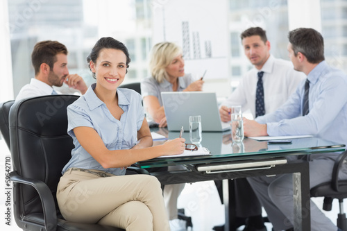 Young businesswoman with colleagues discussing in office