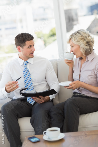 Businessman and his secretary  with diary and tea cup