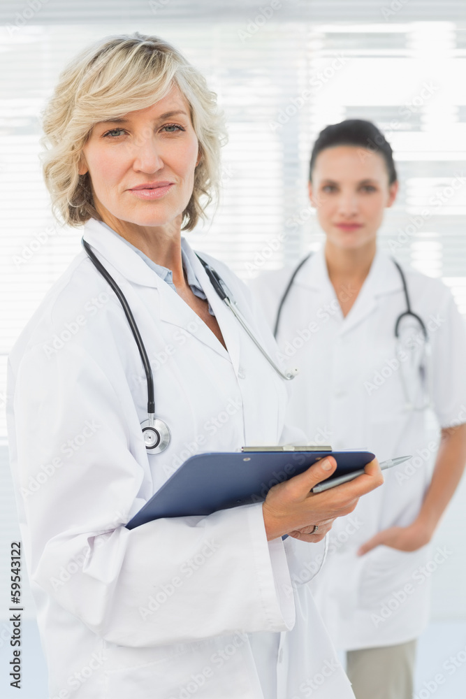 Portrait of a beautiful female doctor with clipboard Portrait of a beautiful female doctor with clipboard