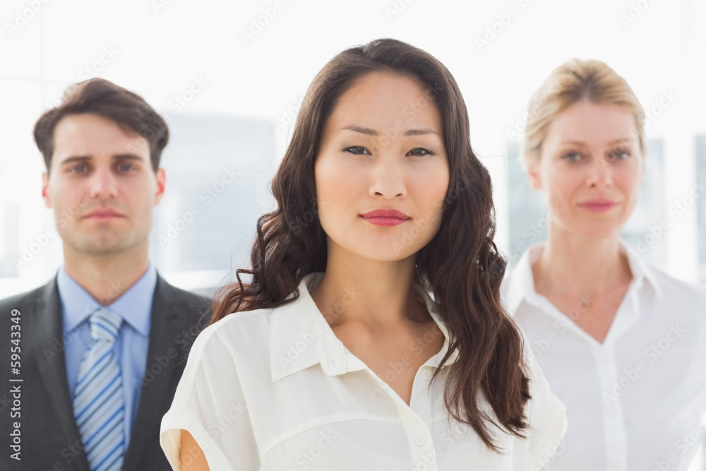 Serious businesswoman in front of her team Serious businesswoman in front of her team
