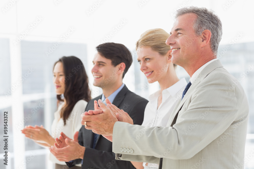 Business team standing in a line applauding Business team standing in a line applauding