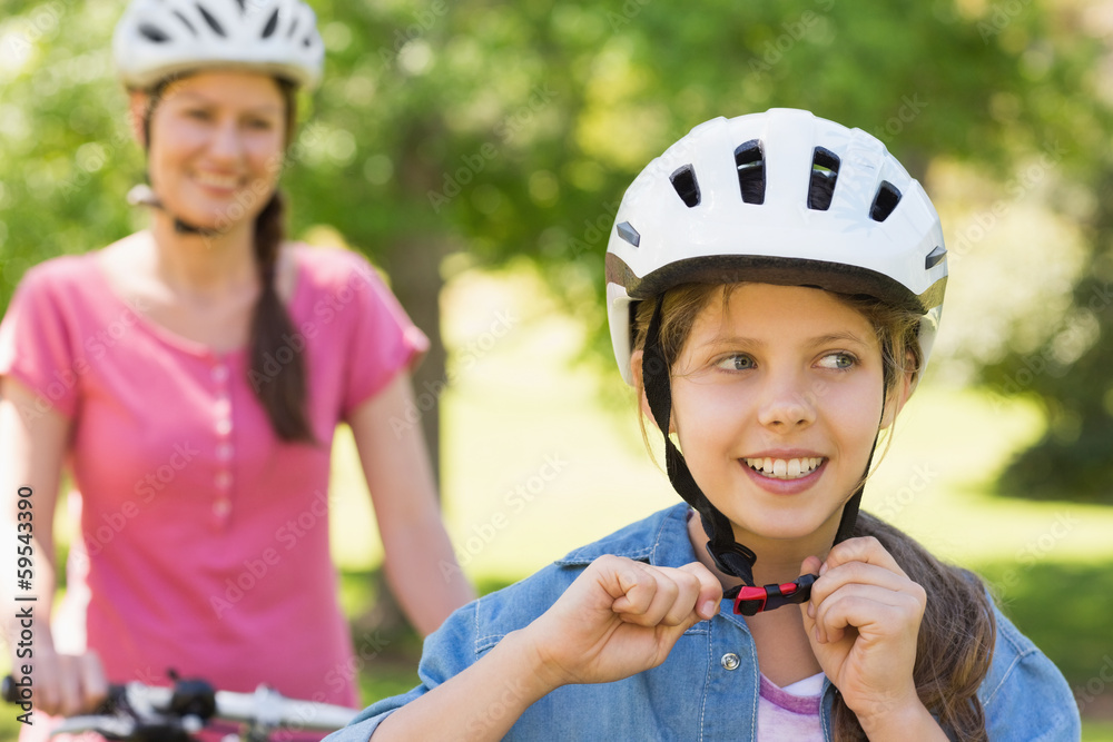 Smiling woman with her daughter riding a bicycle Smiling woman with her daughter riding a bicycle