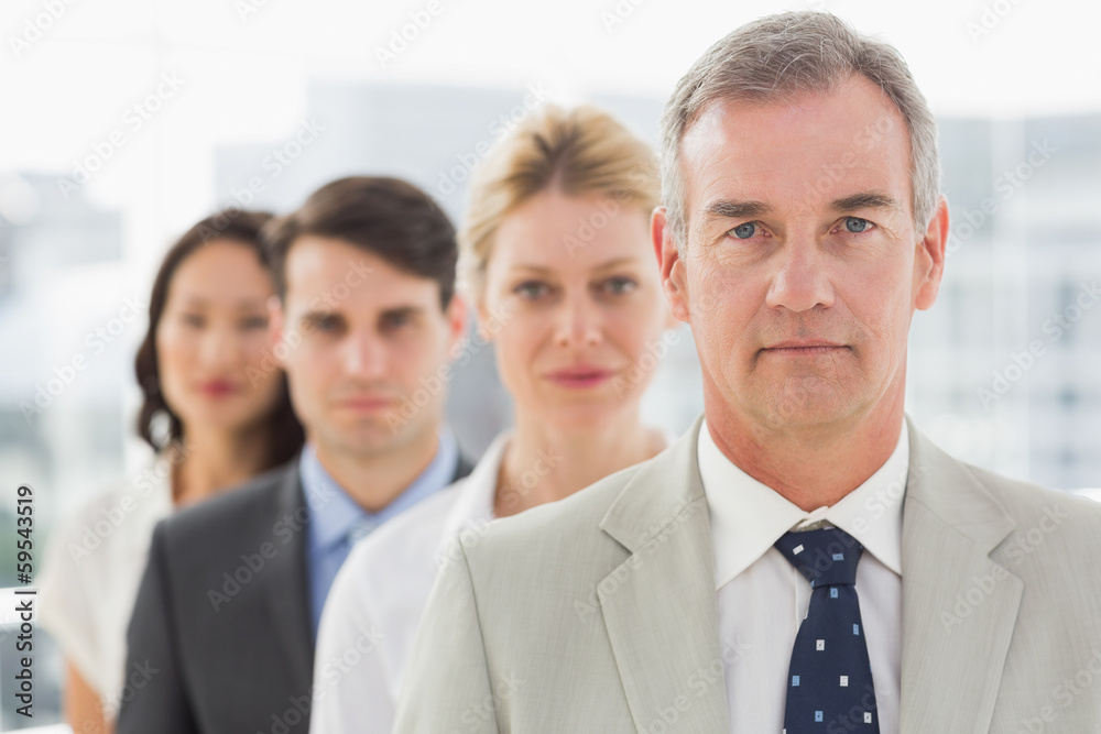 Stern business team standing in a line Stern business team standing in a line