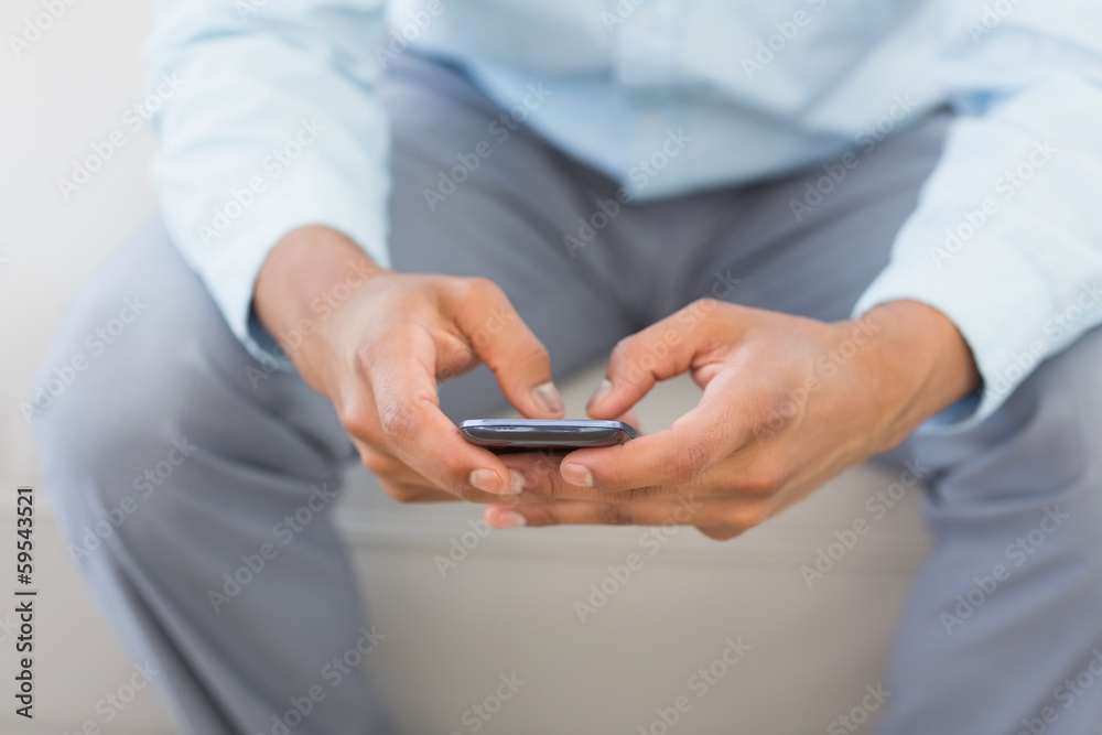 Man sending a text sitting on couch