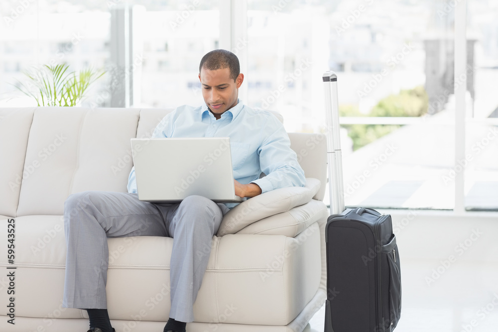 Businessman using laptop waiting to depart on business trip Businessman using laptop waiting to depart on business trip