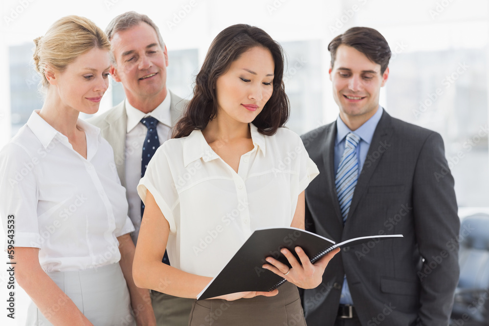 Businesswoman reading a document with her team Businesswoman reading a document with her team