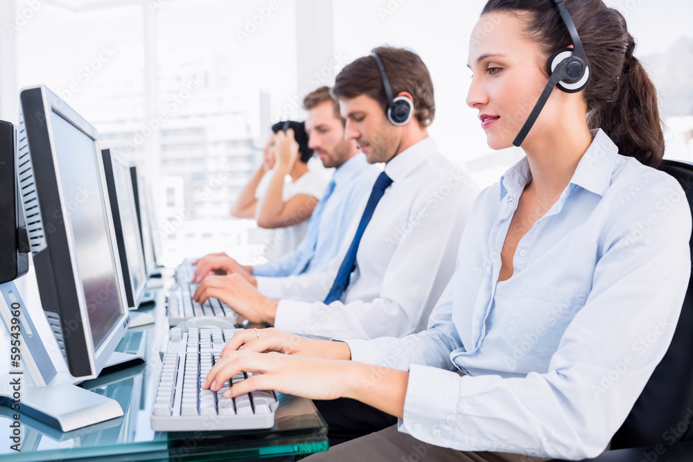 Business colleagues with headsets using computers Business colleagues with headsets using computers