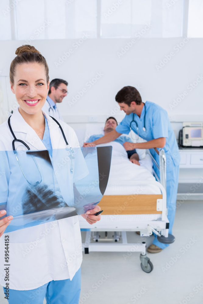 Obraz premium Doctor holding x-ray with surgeons and patient in hospital