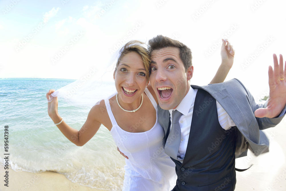 Bride and groom having fun at the beach