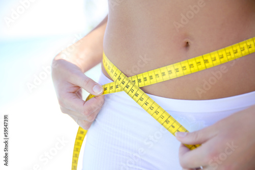 Foto Closeup of woman measuring waist line