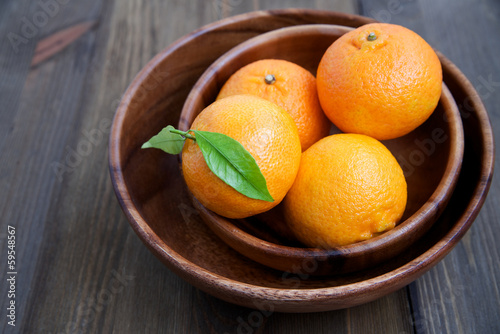 Fotografie Tangerines in a wooden plate